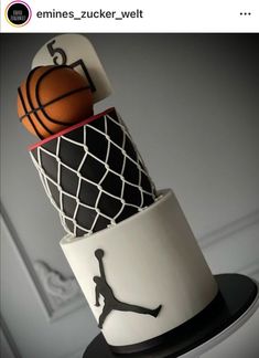 a three tiered cake decorated with basketballs and other sports related items on top