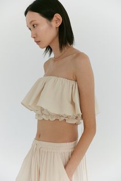 Our signature convertible ruffle top is so versatile, it can adjust to any mood. Manipulated into a countless number of ways, this elasticized top can be worn as a simple tube top, to off the shoulder or even as an asymmetric one shoulder. Choose to tie the long ties into a bow or over the shoulder into spaghetti straps or halter - the possibilities are endless. Made in our dandelion cotton - this fabric features a lightly brushed, textured exterior while maintaining a soft breathable interior. Cotton Ruffle Top, Neutral Loungewear, Diwali 2024, Ruffle Tube Top, Spaghetti Top, Slouch Socks, Loungewear Outfits, Pretty Blouses, Stylish Dress Designs