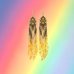 These stunning and sparkling Yawanawa earrings come from Aldeia Yawarany in Acre, Brazil. The Yawanawa are revered for their gorgeous beadwork and earrings. These items have been collected from the daughter of the Cacique, and the women of the village to raise money for the recent floods in Tarauaca. All earrings are one of a kind, hand made and take months to create. Product Description: 1.25'' width and 8'' inch dangling drop with ombre beads and sacred kene design. Traditional Long Drop Beaded Earrings With Dangling Beads, Traditional Yellow Beaded Earrings, Artisan Long Drop Beaded Earrings, Traditional Long Drop Beaded Earrings, Yellow Bohemian Earrings For Festive Occasions, Traditional Yellow Earrings With Colorful Beads, Traditional Yellow Earrings For Festival, Traditional Gold Handwoven Beaded Earrings, Traditional Yellow Beaded Earrings With Dangling Beads