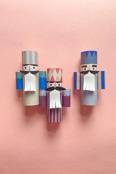 three paper nutcrackers on a pink background