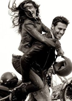 a man riding on the back of a motorcycle next to a woman wearing a leather jacket