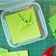 some origami pieces are sitting on a table with scissors and other items to make an origami bird