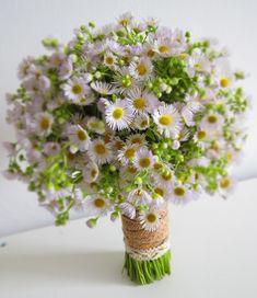 a bouquet of daisies in a vase on a table