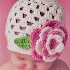 a baby wearing a crochet hat with a flower on it's head