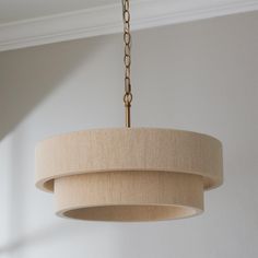 a chandelier hanging from a ceiling in a room with white walls and wood trim