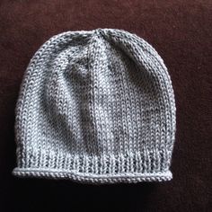 a knitted hat sitting on top of a brown blanket