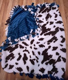 two blankets are laying on the floor with blue and brown animal print, one is folded up