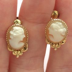 Hand carved genuine shell vintage cameo earrings set in bezel settings have screw backs. These are perfect for non-pierced ears and can be also be easily worn by those with pierced ears. Shiny gold fill oval bezels with saw tooth edging sit atop dainty floral bowers. Earrings are 17 mm long by 11 mm wide ovals with a depth of about 5 mm. Screw backs are signed C.T. and marked 1/20 12K G. F. The carvings are nicely done by hand, the women are similar yet interestingly different from one another. Victorian Cameo Yellow Gold Earrings, Victorian Cameo Earrings For Formal Occasions, Vintage Cameo Round Earrings, Formal Carved Earrings, Classic Cameo Earrings, Classic Cameo Earrings Gift, Vintage Intaglio Earrings For Wedding, Classic Cameo Earrings For Wedding, Elegant Cameo Earrings For Collectors