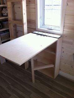 a wooden table sitting in front of a window