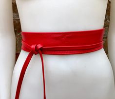 Red waist belt in  genuine leather. Narrower style. Red wraparound belt in soft natural leather. Genuine leather. The color is quite bright, it corresponds to the 6 first pictures of the listing The belt is 220 cm (86 in) long and 5  cm ( 2 in)  at its widest (front) it gets smaller towards the end up to 1 cm (1/2  inch).  Our genuine leather and soft suede obi belts  in different colors: https://www.etsy.com/es/shop/goodtimesbarcelona?section_id=10691564 This listing is for the belt only.  Matc Adjustable Corset Belt For Spring, Spring Leather Corset Belt, Leather Corset Belt For Spring, Fitted Sashes For Spring, Elegant Leather Belts For Festival, Elegant Leather Belt For Festival, Elegant Leather Festival Belts, Chic Red Leather Belt, Obi Belts