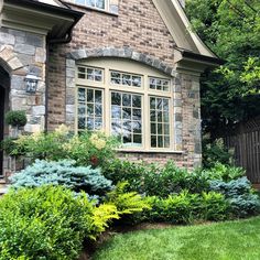 a house that has some plants in the front yard and bushes on the side of it