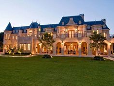 a large house with lots of windows and lights on it's front lawn area