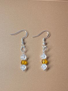 Beaded white and orange dangle earrings White Hypoallergenic Drop Crystal Earrings, Amber Beaded Dangle Earrings, Amber Beaded Drop Earrings For Gift, Amber Beaded Drop Earrings, Handmade White Dangle Crystal Earrings, Handmade White Crystal Dangle Earrings, White Crystal Drop Earrings With Ear Wire, White Dangle Crystal Earrings Gift, White Hypoallergenic Beaded Earrings As Gift