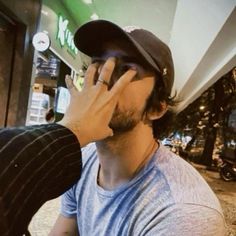 a man talking on his cell phone while sitting in front of a storefront window