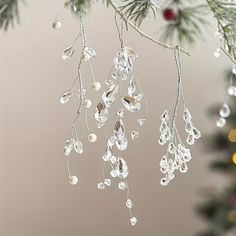 an ornament hanging from a christmas tree with beads and pearls attached to it