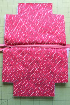 two pieces of pink fabric with white polka dots on them, one piece is cut in half