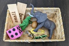 a toy elephant in a basket with other toys