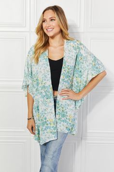 A stunning fashion piece that effortlessly combines elegance, comfort, and a touch of playfulness. This kimono is designed to make a statement and elevate your wardrobe to new heights of style. The colors burst with life, creating a mesmerizing visual effect that is sure to turn heads wherever you go. The soft, flowing fabric drapes gracefully over your body, exuding an air of sophistication and grace. What sets this kimono apart is the exquisite ruffle side detail. The delicate ruffles cascade down the sides, adding a touch of whimsy and femininity to the design. Pattern type: Floral Style: Casual, Chic Features: Ruffle Neckline: Open front Length: Long Sleeve length: Short sleeves Sleeve type: Dolman sleeves Sheer: Yes Material composition: 100% polyester Stretch: No stretch Care instruc Chic Wrap Cover-up For Spring, Spring Flowy Wrap Cover-up, Oversized V-neck Spring Cover-up, Spring Floral Print Outerwear For Loungewear, Oversized Spring Cover-up For A Day Out, Spring V-neck Relaxed Fit Cover-up, Chic Wrap Summer Outerwear, Chic Green Summer Cardigan, Chic Summer Wrap Outerwear