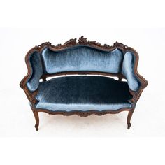 an old fashioned couch with blue velvet upholstered to it's back end