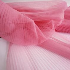 pink pleated fabric laying on top of each other