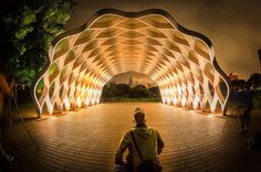 a man is sitting on the ground in front of a large structure that looks like he has