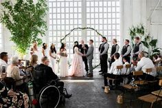 a group of people standing next to each other in front of a wedding ceremony arch