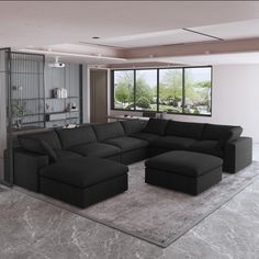 a large black couch sitting in a living room next to a tall glass window on the wall