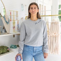 a young woman standing in front of a display of necklaces and jewelry at a store