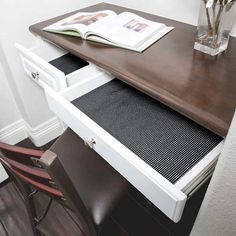 a desk with a book and some flowers on it