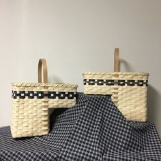 two wicker baskets sitting on top of a blue and white checkered table cloth