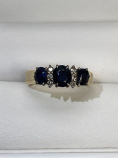 three sapphire and diamond rings in a box