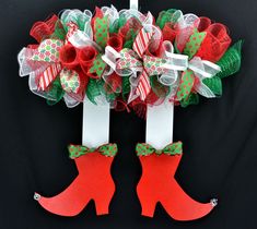 two christmas stockings with bows on them are attached to the door hanger for decoration