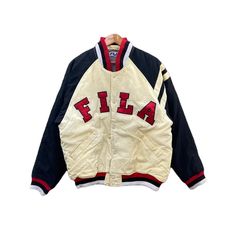 DESCRIPTIONS & MEASUREMENTS TAG BRAND : FILA MADE : CHINA SIZE ON TAG : M (Please check the actual measurements below) PIT TO PIT : 24.5 INCH LENGTH : 27.5 INCH SLEEVE LENGHT : 24 INCH CONDITION : Good Condition 8/10 Measurement manual (when laid on floor) PAYMENT  : PAYPAL ONLY Please DROP your PHONE NUMBER after purchase for the delivery process. ATTENTION   Please pay close to measurement provided. Do not rely on tag size. The best way to ensure fits is compare with measurement of item that you usually wear. Enlarge the photo for clearer image.  Thank you... White Varsity Jacket With Embroidered Logo For Streetwear, Sporty Cotton Varsity Jacket With Embroidered Logo, Retro Cotton Varsity Jacket With Letter Print, Retro Cotton Varsity Jacket For Sports, Sporty Cotton Outerwear With Logo Print, Sporty Varsity Jacket With Embroidered Logo For Sports Events, Sporty College Outerwear With Logo Print, Retro Track Jacket With Baseball Collar, Crew Neck Varsity Jacket With Embroidered Logo For Streetwear