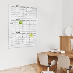 a desk with two chairs and a calendar on the wall