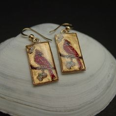 "Hand carved cloisonne bird cardinal earrings ( oiseau, vogel). One of our most popular birds, the Cardinal is the official state bird of no fewer than seven eastern states. Abundant in the Southeast, it has been extending its range northward for decades, and it now brightens winter days with its color and its whistled song as far north as southeastern Canada. Feeders stocked with sunflower seeds may have aided its northward spread. The cardinal bird is also known for representing celebration, r Elegant Drop Earrings With Bird Design, Elegant Bird Design Drop Earrings, Gold Hand Painted Jewelry For Formal Occasions, Hand Painted Red Elegant Earrings, Elegant Hand Painted Red Earrings, Bird Design Enamel Jewelry Gift, Enamel Jewelry With Bird Design For Gifts, Bird-shaped Jewelry Set With Matching Earrings, Elegant Red Hand Painted Jewelry