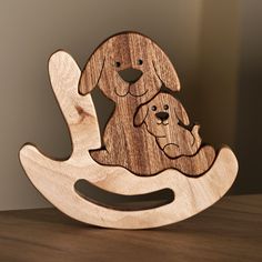 a wooden rocking toy with a dog on it's back and a cat in the middle