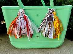 two bags are decorated with ribbons and laces on the handles, one is green