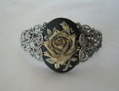 This beautiful silver plated filigree cuff bracelet has a rose cameo setting with silver plated filigree accents on the sides. Adjustable. Elegant Adjustable Cameo Bracelets, Ornate Carved Jewelry For Formal Occasions, Vintage Silver Cameo Bracelet, Silver Cameo Bracelet For Gifts, Unique Antique Silver Bracelets For Formal Occasions, Elegant Wedding Cameo Bracelets, Elegant Silver Bracelet With Cameo, Elegant Cameo Wedding Bracelets, Silver Metal Cameo Jewelry