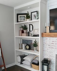 a living room with a fireplace and bookshelf filled with various items on top of it