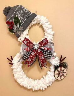 a christmas wreath made out of yarn and knitted fabric with two hats on top