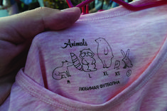 a person holding onto a pink shirt with animals on it