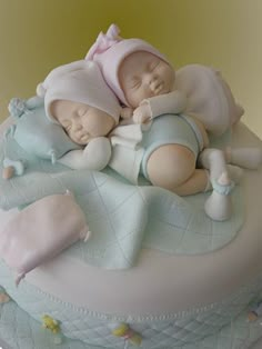 there is a cake that has two baby dolls on it, and one is sleeping