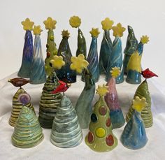 a group of colorful glass vases sitting on top of a white cloth covered table