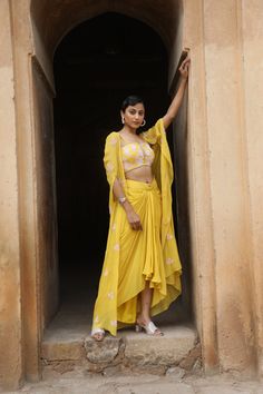 Featuring Yellow silk bustier with sequence, cutdana, beads embroidered, paired with crepe drape skrit and georgette cape. Fabric - Silk, Georgette and Crepe Components - 3 Colour - Yellow Embroidery details - Hand Embroidery Delivery time - 2-3 weeks Washing Instructions - Dry-clean Diwali Sets With Cape Sleeves In Georgette, Diwali Georgette Sets With Cape Sleeves, Anarkali Palazzo Set With Cape Sleeves In Georgette, Navratri Georgette Palazzo Set With Cape Sleeves, Festive Georgette Sharara With Cape Sleeves, Festive Georgette Anarkali Set With Cape Sleeves, Georgette Anarkali Set With Cape Sleeves And Dupatta, Georgette Lehenga With Sheer Dupatta And Cape Sleeves, Diwali Anarkali Set With Cape Sleeves