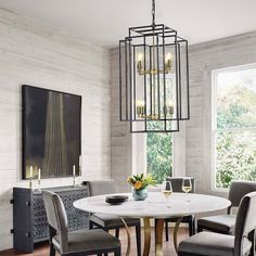 a dining room table with four chairs and a chandelier hanging from the ceiling