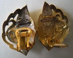 two gold colored metal buckles on white surface