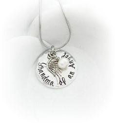 "Can be customized! To personalize: Please leave a note during checkout including the words you would like (if different than \"Grandma of an Angel\"). This necklace is a special keepsake for a Grandmother who has experienced the loss of a grandchild. I have hand stamped, one letter, one hammer strike at a time, \"Grandma of an Angel\" onto a hypoallergenic aluminum disc and added an angel wing charm, and a freshwater pearl. The round 1\" pendant is made of lightweight hypoallergenic grade alumi Keepsake Pendant Jewelry With Name, Memorial Birthstone Necklaces, Nickel-free Charm Necklaces For Mother's Day Keepsake, Memorial Jewelry With Name For Mother's Day, Memorial Jewelry For Mother's Day With Name Detail, Memorial Jewelry Named For Mother's Day, Customizable Silver Necklace For Memorial, Memorial Mother's Day Named Jewelry, Customizable Silver Memorial Necklace