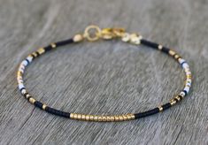 Dainty gold bracelet for women, made with very tiny Miyuki glass beads in gold, black and white. This thin bead bracelet has a stainless steel gold lobster clasp. This delicate bracelet stands perfect on its own (minimalist style), or combine with other bracelets to create your personal stack! MATERIALS: -11/0 Miyuki delicas (1.6mm x 1.3mm) -stainless steel gold colored closure DIMENSIONS: Choose your size in the variations (note: you choose the size of the bracelet, not the wrist circumference! Miyuki Delica Bracelet, Black And Gold Bracelet, Bracelet Stands, Festival Bracelets, Turquoise Anklet, Homemade Bracelets, Beaded Ankle Bracelets, Dainty Gold Bracelet, Miyuki Bracelet