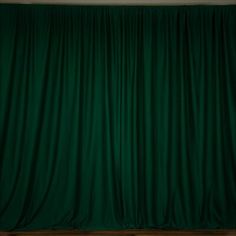 a green curtain with wooden floors in front of it