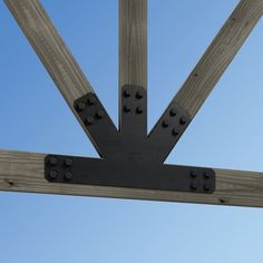 an overhead view of a wooden structure with rivets on the side and blue sky in the background